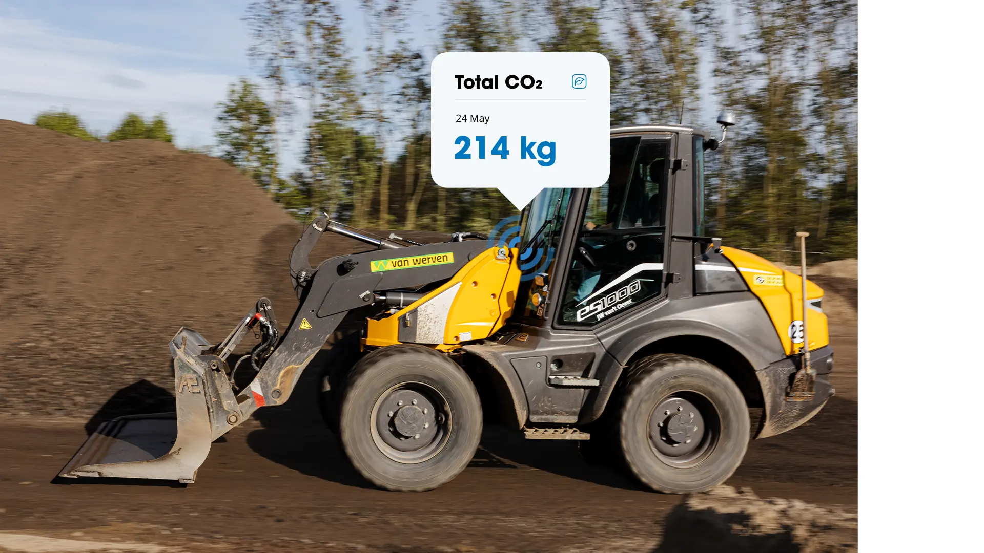 Yellow Van Werven wheel loader driving on an unpaved road, with a pop-up showing 214 kg of CO&sup2; on 24 May
