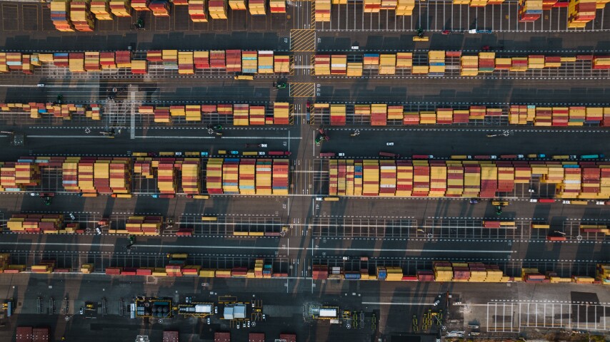 Aerial view of a cargo port with rows of colorful shipping containers.