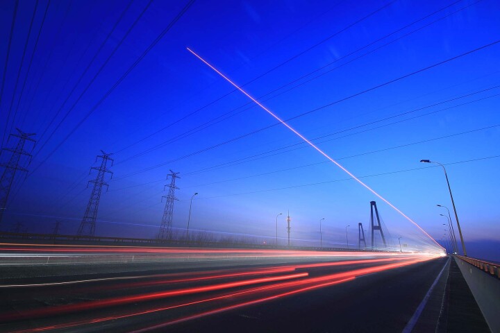 Langs een snelweg met lichtsporen van voertuigen bij schemering, symboliseert deze foto innovatie, connectiviteit en beweging binnen moderne infrastructuur. |GPS-Buddy