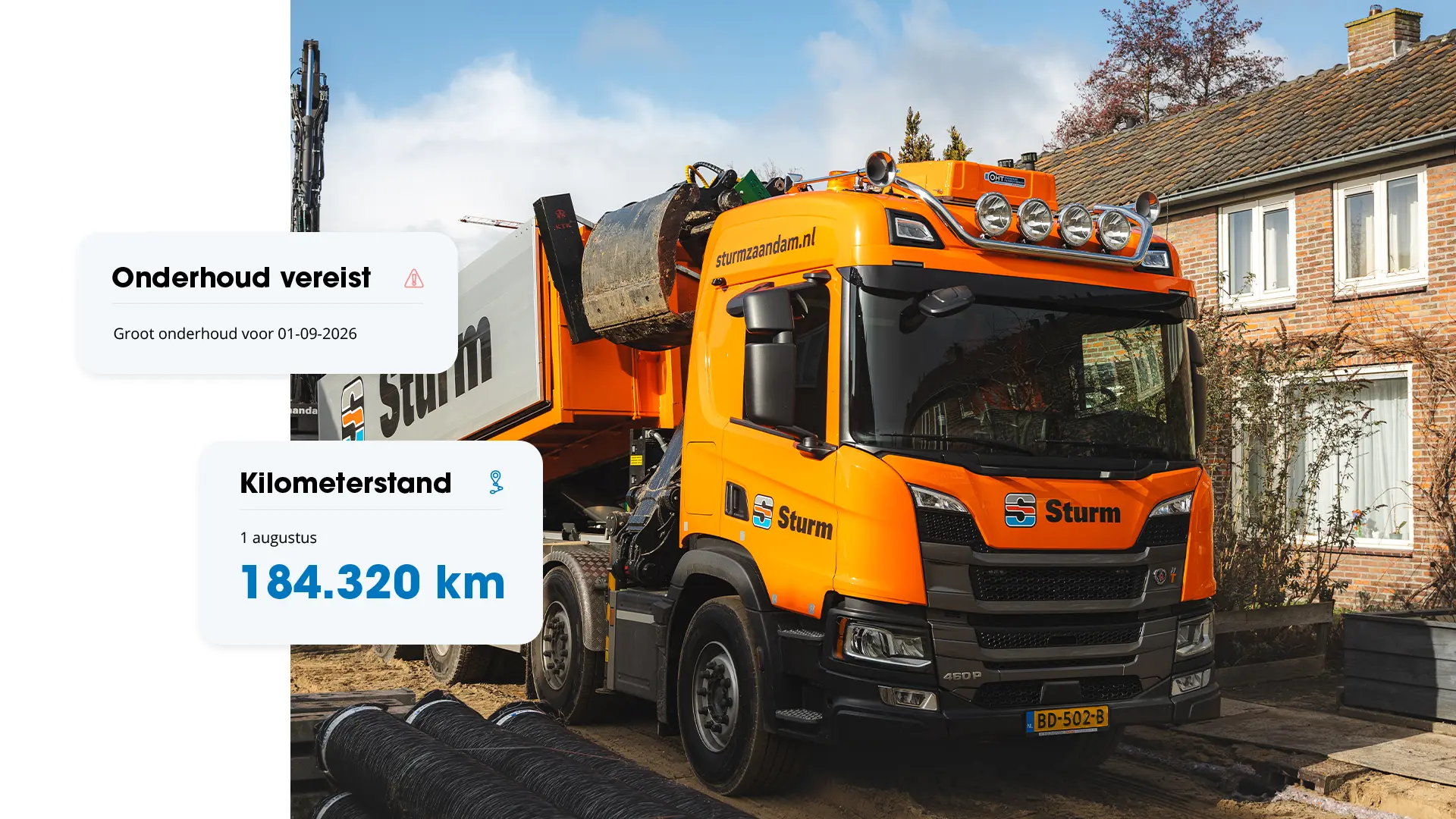 Oranje Sturm-kiepwagen in woonwijk met kaarten die 184.320 km en gepland groot onderhoud tonen