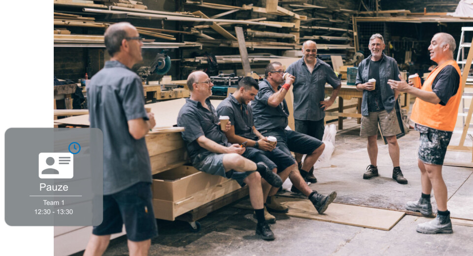 "Groep mannen in werkoutfits houdt een pauze in een werkplaats, met een digitale overlay voor pauzetijden van team 1.